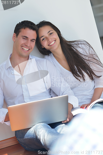Image of young couple using laptop at home