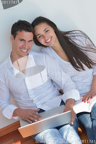 Image of young couple using laptop at home