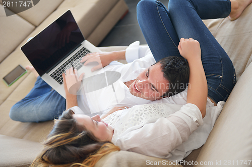 Image of young couple using laptop at home