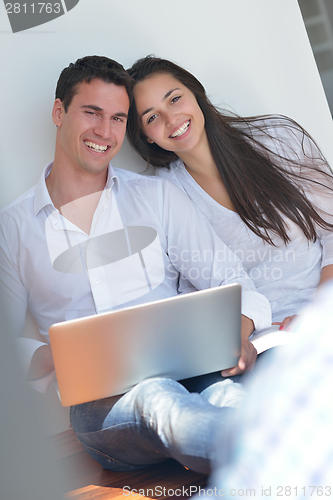 Image of young couple using laptop at home