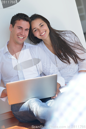 Image of young couple using laptop at home