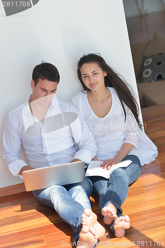 Image of young couple using laptop at home