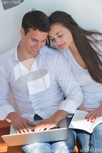 Image of young couple using laptop at home