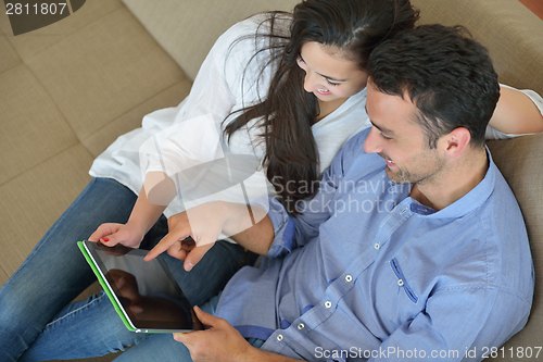 Image of couple at home using tablet computer