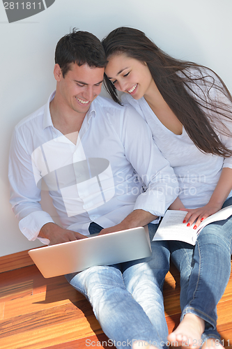 Image of young couple using laptop at home