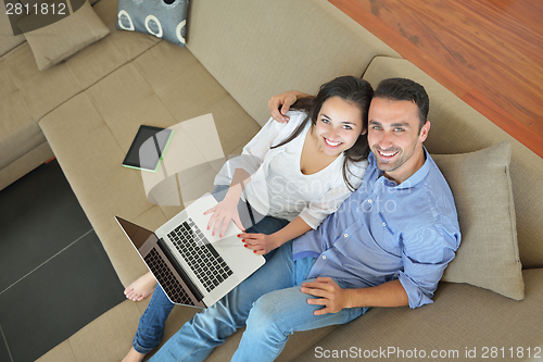 Image of young couple using laptop at home
