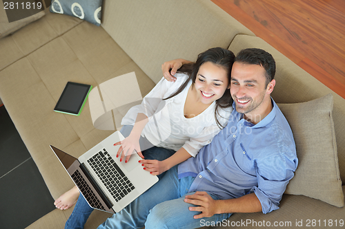 Image of young couple using laptop at home