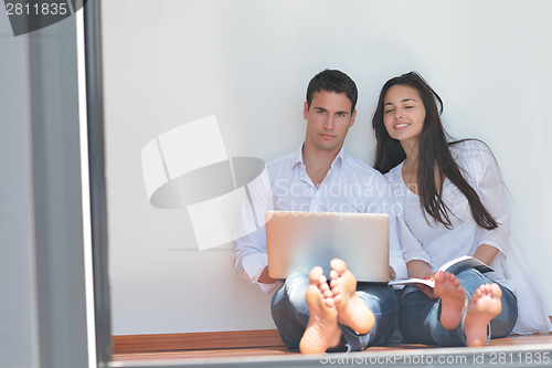 Image of young couple using laptop at home