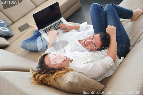 Image of young couple using laptop at home