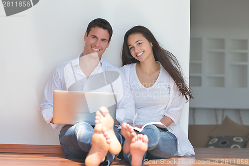 Image of young couple using laptop at home