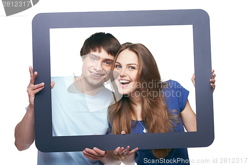 Image of Happy couple looking through tablet frame