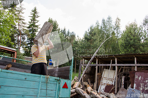 Image of worker man unload tree log firewood from trailer 