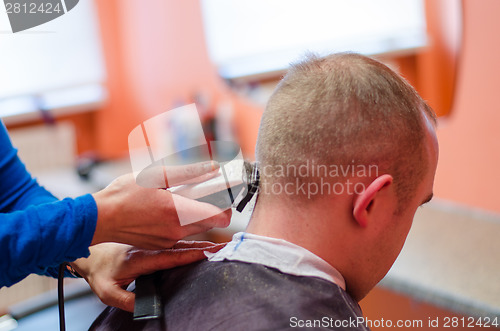 Image of hairdresser shape man haircut with clipper  