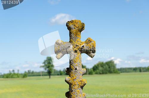 Image of retro concrete cross on cloudy sky 