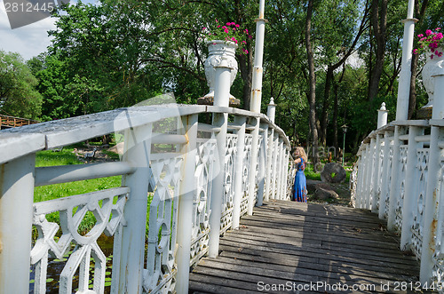 Image of bridge wiggle railings and girl resting at bridge 
