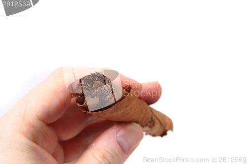 Image of old cigar in human hand