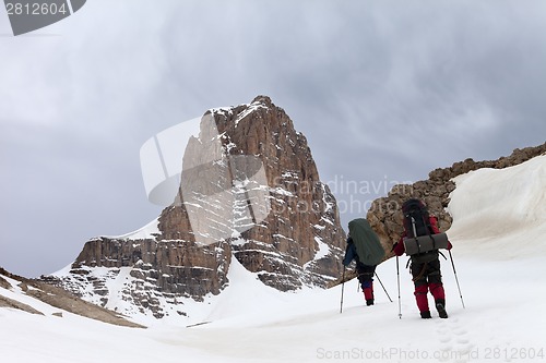 Image of Two hikers in snowy mountains before storm