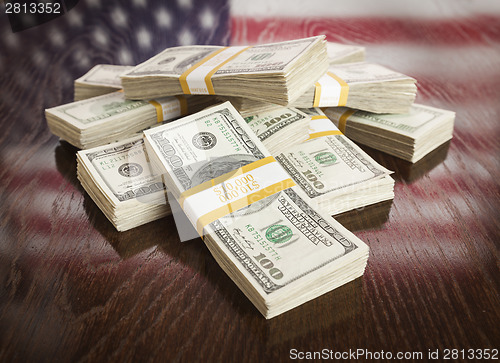 Image of Thousands of Dollars with Reflection of American Flag on Table