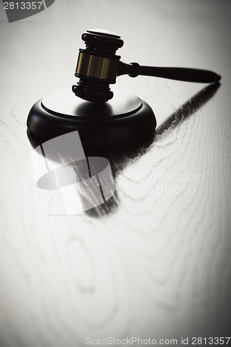 Image of Dramatic Gavel Silhouette on Reflective Wood