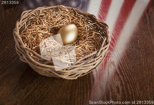 Image of Golden Egg in Nest with American Flag Reflection on Table