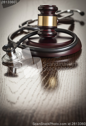 Image of Gavel and Stethoscope on Reflective Table