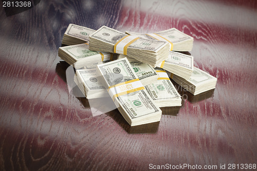 Image of Thousands of Dollars with Reflection of American Flag on Table