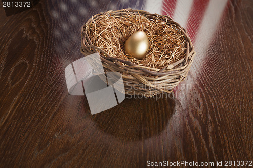 Image of Golden Egg in Nest with American Flag Reflection on Table