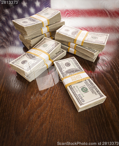 Image of Thousands of Dollars with Reflection of American Flag on Table