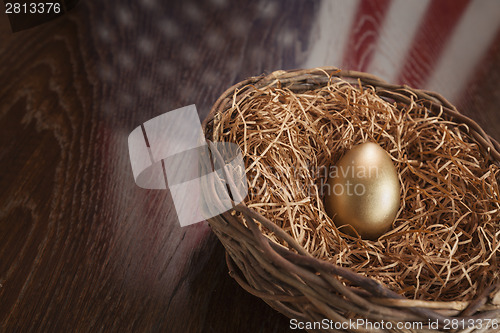 Image of Golden Egg in Nest with American Flag Reflection on Table