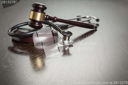 Image of Gavel and Stethoscope on Reflective Table