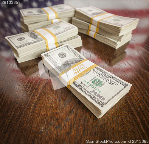Image of Thousands of Dollars with Reflection of American Flag on Table