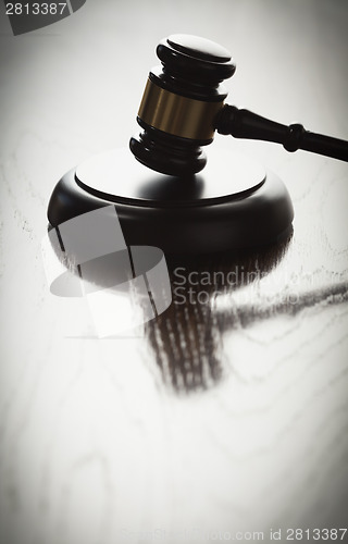 Image of Dramatic Gavel Silhouette on Reflective Wood