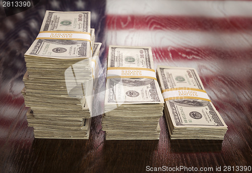 Image of Thousands of Dollars with Reflection of American Flag on Table