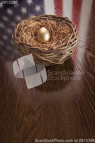 Image of Golden Egg in Nest with American Flag Reflection on Table