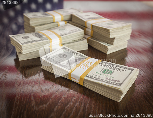 Image of Thousands of Dollars with Reflection of American Flag on Table