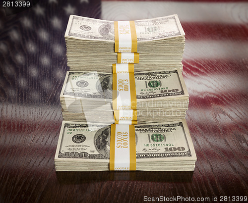 Image of Thousands of Dollars with Reflection of American Flag on Table