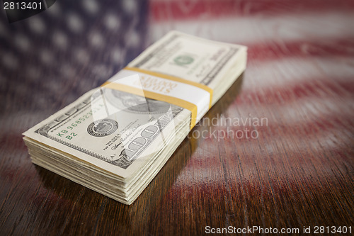 Image of Thousands of Dollars with Reflection of American Flag on Table