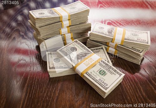 Image of Thousands of Dollars with Reflection of American Flag on Table