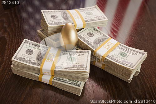 Image of Golden Egg and Thousands of Dollars with American Flag Reflectio