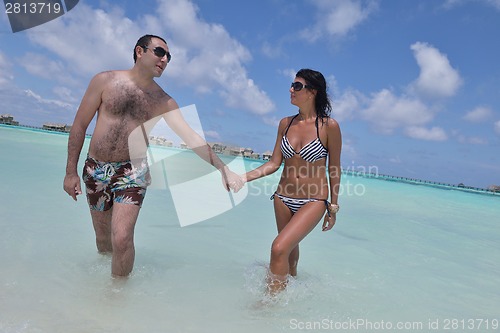 Image of happy young couple have fun on beach