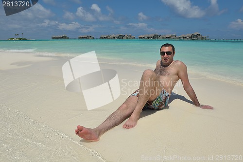 Image of young man have fun and relax on beach