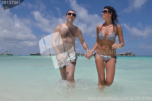 Image of happy young couple have fun on beach