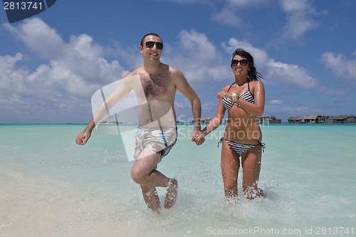 Image of happy young couple have fun on beach