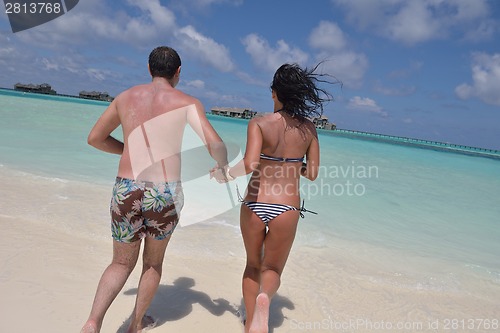 Image of happy young couple have fun on beach