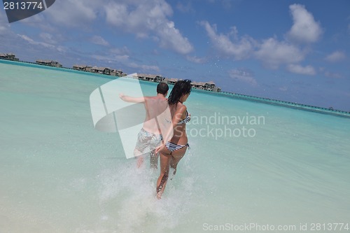 Image of happy young couple have fun on beach