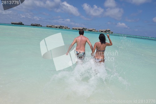 Image of happy young couple have fun on beach