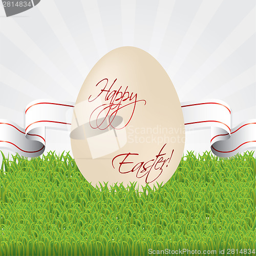 Image of Easter egg with ribbon in grass