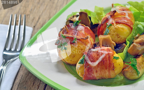 Image of Baked potatoes wrapped in bacon