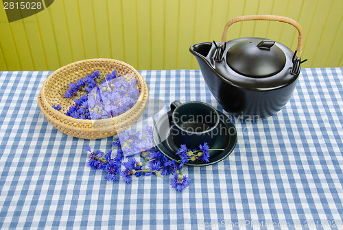Image of fresh cornflower tea set on blue white tablecloth 
