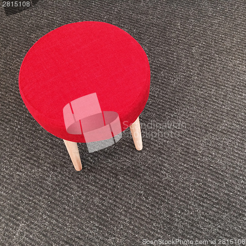 Image of Red stool on gray carpet floor